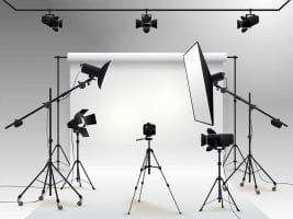 Photography studio with lights and cameras pointing at a white backdrop